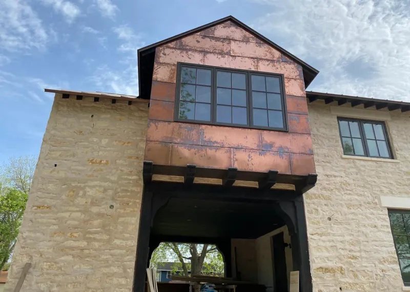 Copper metal panel facade on a stone building for Roof Repair in Eden Prairie